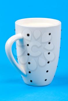 cupful of milk on blue background