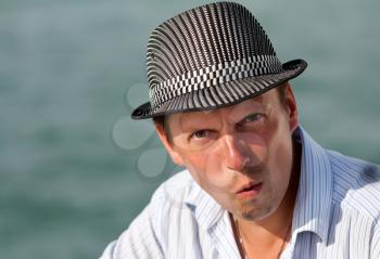 portrait of a man in a hat amazed at the background of the azure sea