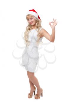 happy laughing blond woman in red santa hat shows Ok, isolated against white background