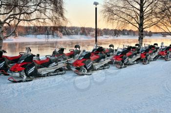Vehicles are a number of snowmobiles in the parking lot