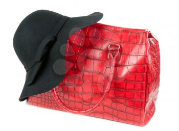 Red Fashion ladies handbag and a black felt hat in the studio on a white background