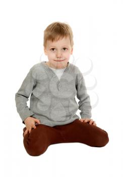 child is sitting in the studio on a white background