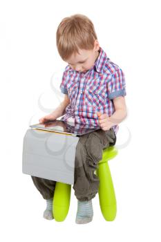 boy with a Tablet PC sitting on a chair in the studio isolated on white background