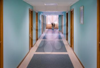 The corridor with blue walls and wooden doors