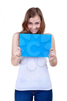 Portrait of a beautiful girl smiling playfully showing a blank blue sheet of paper, isolate on white