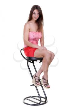 Portrait of a beautiful girl sits on the bar stool isolate on a white background
