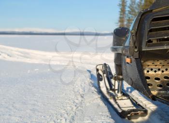 fragment of a snowmobile against a winter landscape