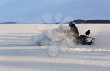 man rushes a snowmobile on a snow plain