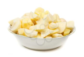plate with peeled potatoes cut into pieces. Isolate on white