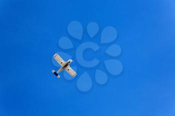 Small flying aircraft in a blue sky