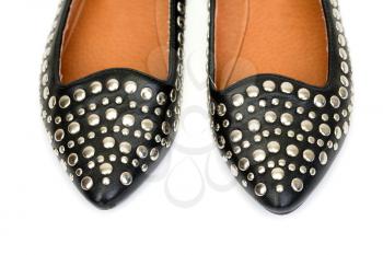 Black women's leather ballet flats with steel rivets close up on a white background