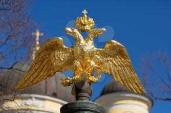 golden double-headed eagle on a background of blue sky and the domes of the church