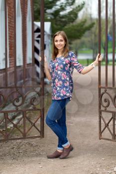 Full-length portrait of a beautiful girl with a fence