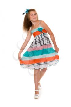 11 year old girl dances in colorful dress in the studio. Isolate on white.