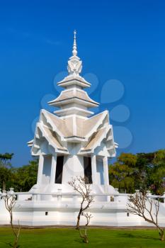 spire of the White Temple in Chiang Mai, Thailand, on a background of blue sky