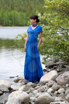 Girl in blue evening dress on a blue lake