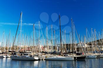 Yacht mast in the port of Barcelona, Spain, rich blue sky with clouds.