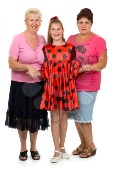 Three generations of women. A studio shot of a mother her daughter and granddaughter dressed in pink and red.
