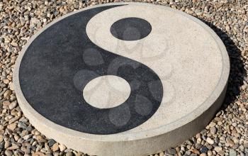 Yin yang sign on a stone on the shingle