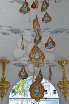 Buddha medallions hanging from the ceiling in a Thai temple. Chang-May, the White Temple.