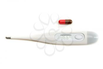 Electronic thermometer and pill on white isolate.