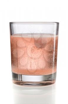 Orange effervescent tablet in a glass of water. Isolate.