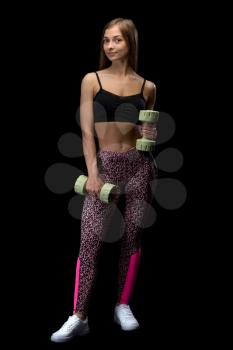 Brunette fitness woman with dumbbells. Isolate in studio on a black background.