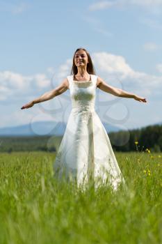 Girl in a wedding dress in his arms flying field