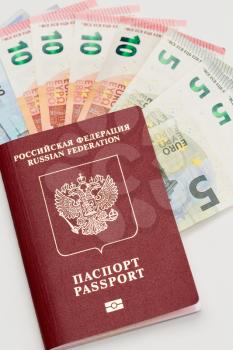 Red international passport and euro banknotes.