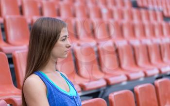 Portrait in profile of a girl at the stadium.
