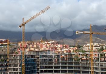 Construction with construction cranes in the background of the volcano on the island of Tenerife, Spain.