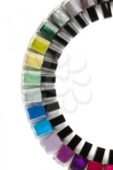 Bottles with nail polish arranged in a semicircle. Vertical frame. Isolate on white.