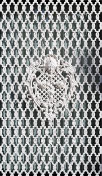 White ornamental grille with wrought pattern.