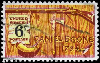 Royalty Free Photo of 1968 US Stamp Shows  Rifle, Powder Horn, Tomahawk Pipe & Knife, Devoted to Daniel Boone (1734-1820)