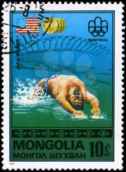 MONGOLIA - CIRCA 1976: A Stamp printed in MONGOLIA shows the John Naber, Montreal Games Emblem, US Flag, Gold Medals from the series Gold medal winners, 21st Olympic Games, Montreal, Canada, circa 