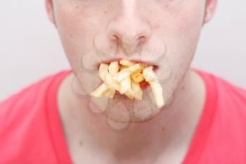Royalty Free Photo of a Man With a Mouthful of French Fries