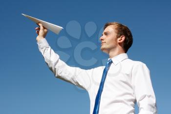 Royalty Free Photo of a Businessman Holding a Paper Airplane