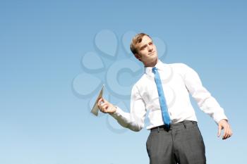 Royalty Free Photo of a Businessman Throwing a Paper Airplane