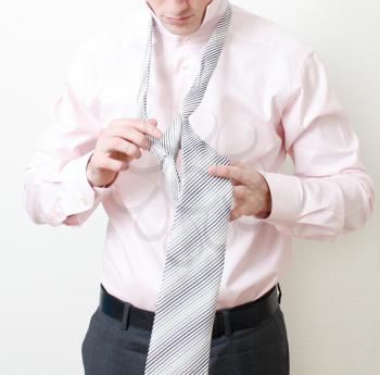 Royalty Free Photo of a Man Putting on a Tie