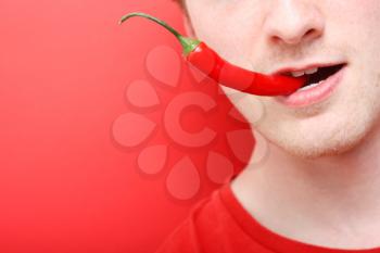 Royalty Free Photo of a Man Eating a Chili Pepper
