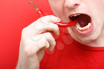 Royalty Free Photo of a Man Eating a Chili Pepper