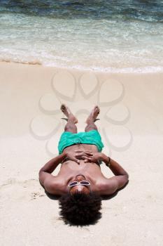 Royalty Free Photo of a Man Sleeping at the Beach