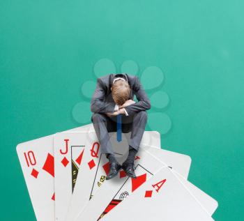 A gambler sitting on cards