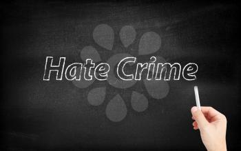 Hate crime written on white blackboard