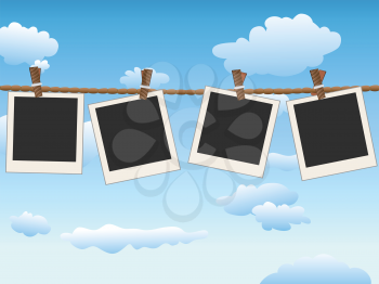 4 Blank photo frames hanging on the rope in blue sky