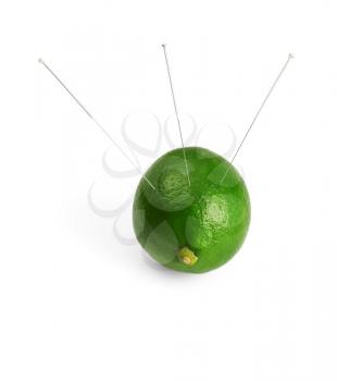 lime with acupuncture needles isolated on white background