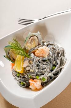 fresh seafood black squid ink coulored spaghetti pasta tipycal italian food