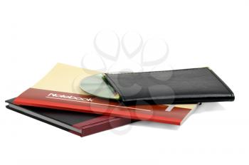 assorted notebooks with a cd flat piled on white background