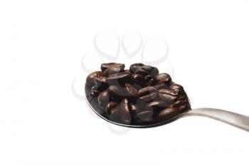 coffee beans on a spoon close-up on white background