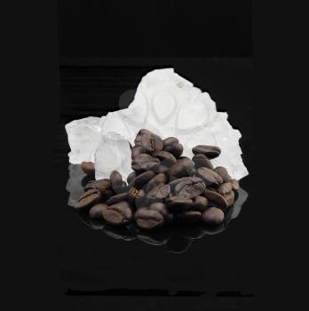 crystal sugar and coffee beans  over black reflective surface background